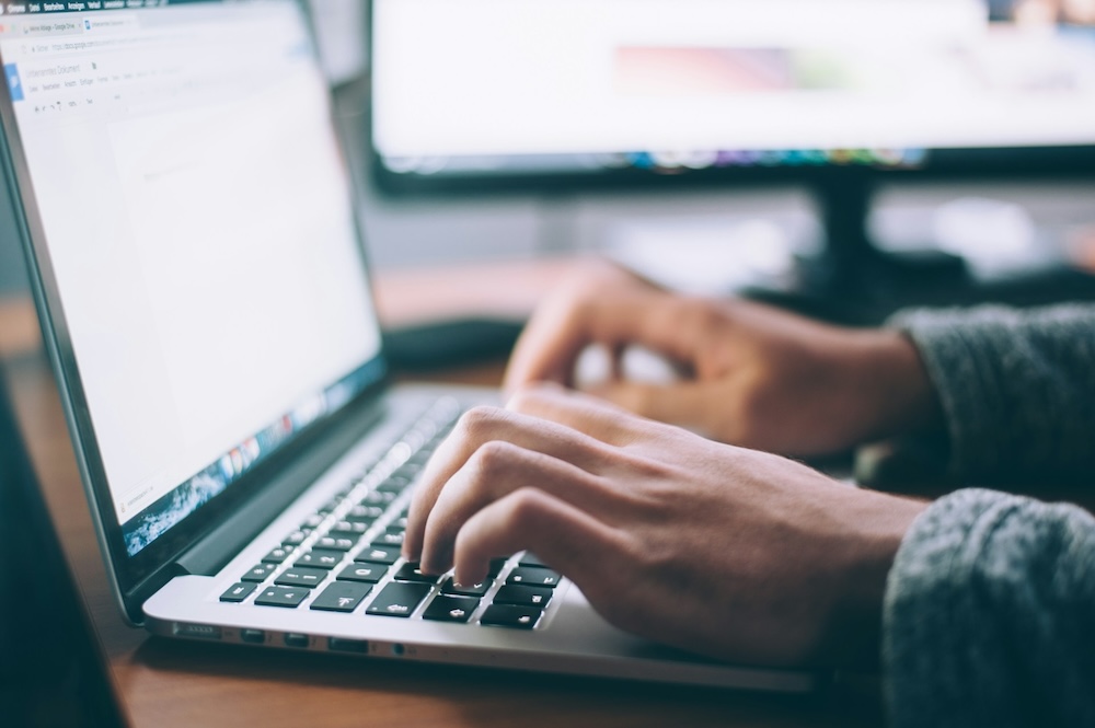 person writing laptop