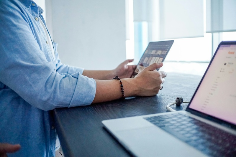 person looking at tablet and laptop