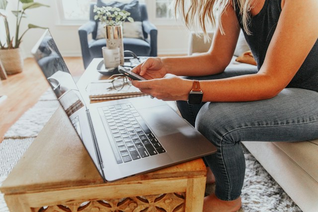 woman at home using laptop and smartphone